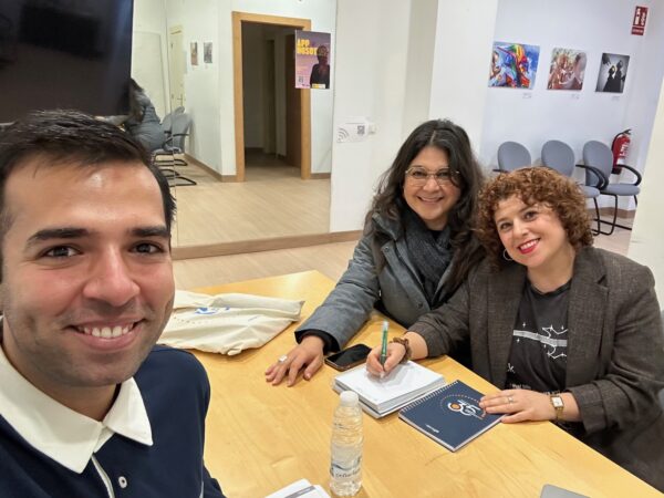 Tres personas reunidas en una oficina